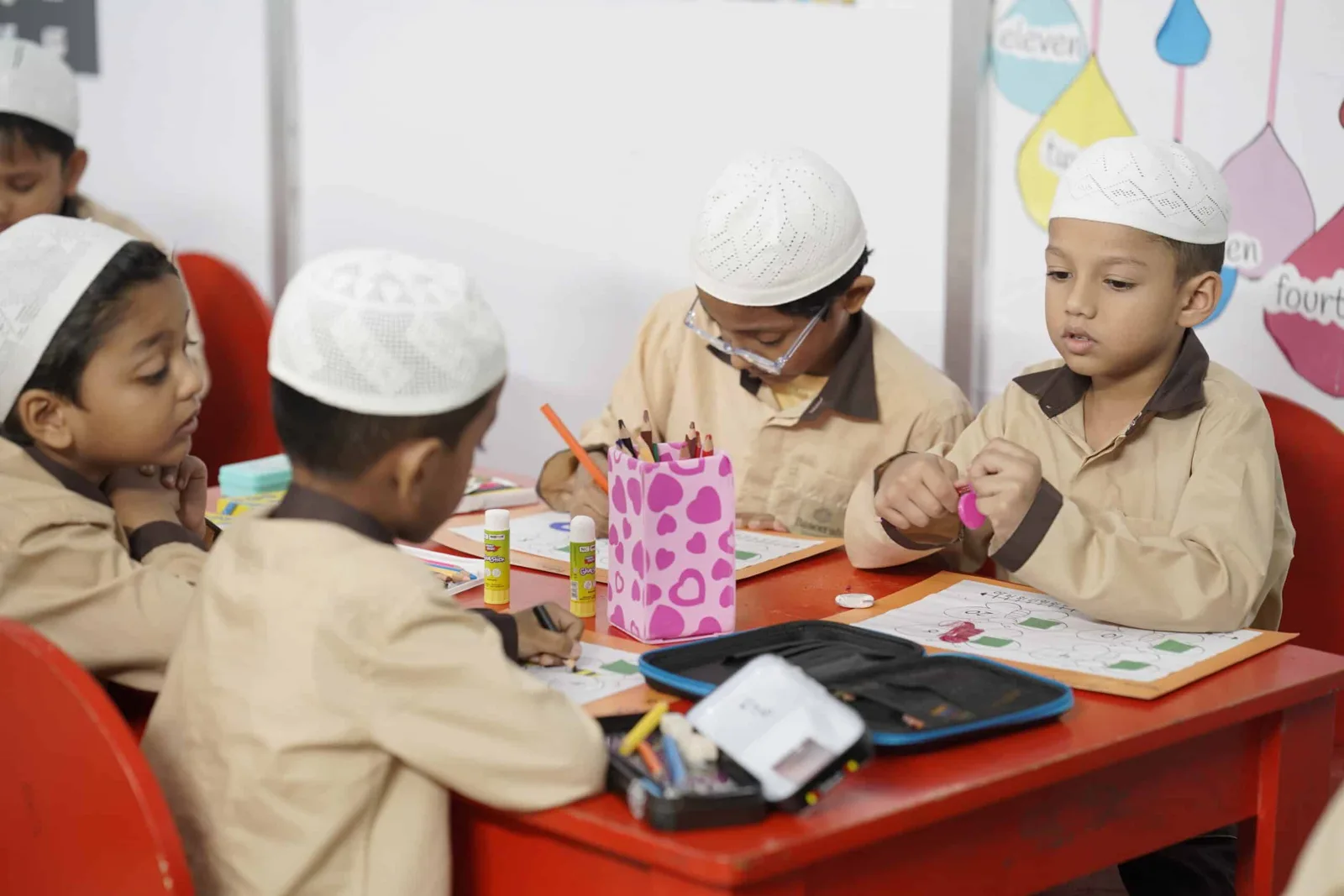 Young boys painting together at a classroom table